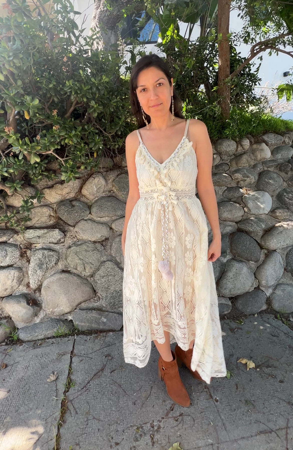 Woman in Beige Sleeveless Lace Cami Dress Boho Tassel facing forward