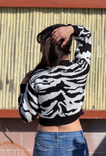 Woman in Black Zebra Print Crop Sweater facing backwards up close