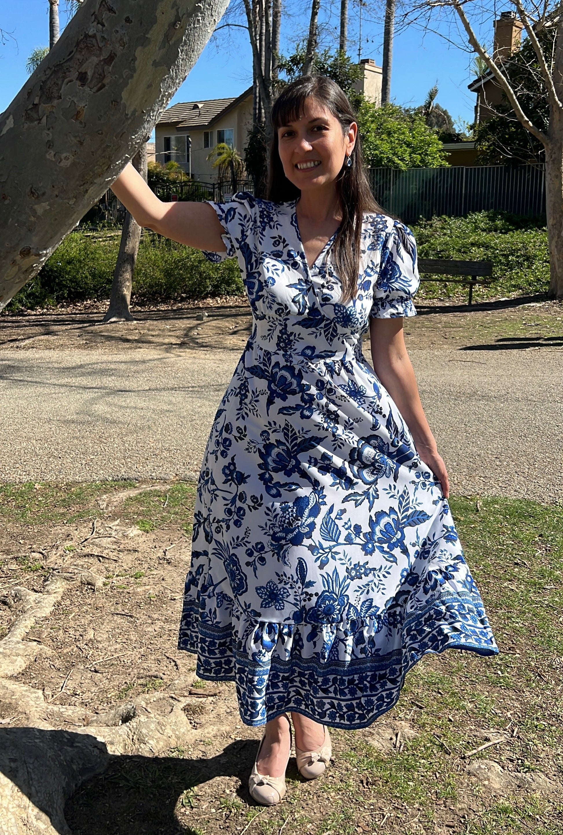 Woman in Blue Floral Puff Sleeve Midi Dress with V-Neck facing forward