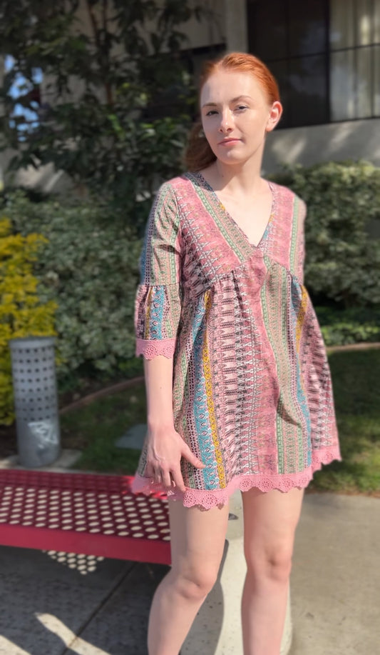 Woman in Boho Chic Pink Striped Mini Dress with Lace Trim – Flowy & Feminine Facing forward