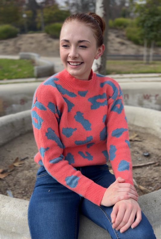 Woman in Coral Leopard Print Pullover Sweater facing forward up close