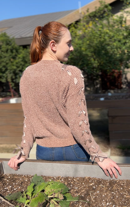 Woman in Khaki Lace Up Sleeve Knit Sweater facing backwards up close