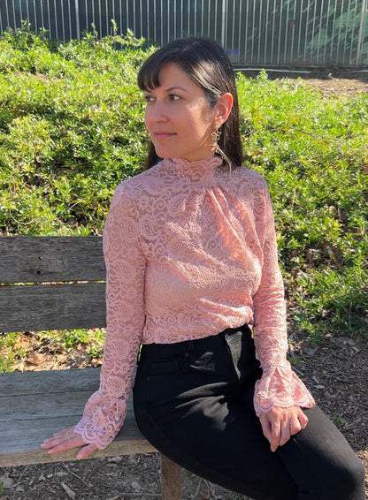 Woman in Pink Floral Lace Mock Neck Top with Flare Sleeves facing forward up close