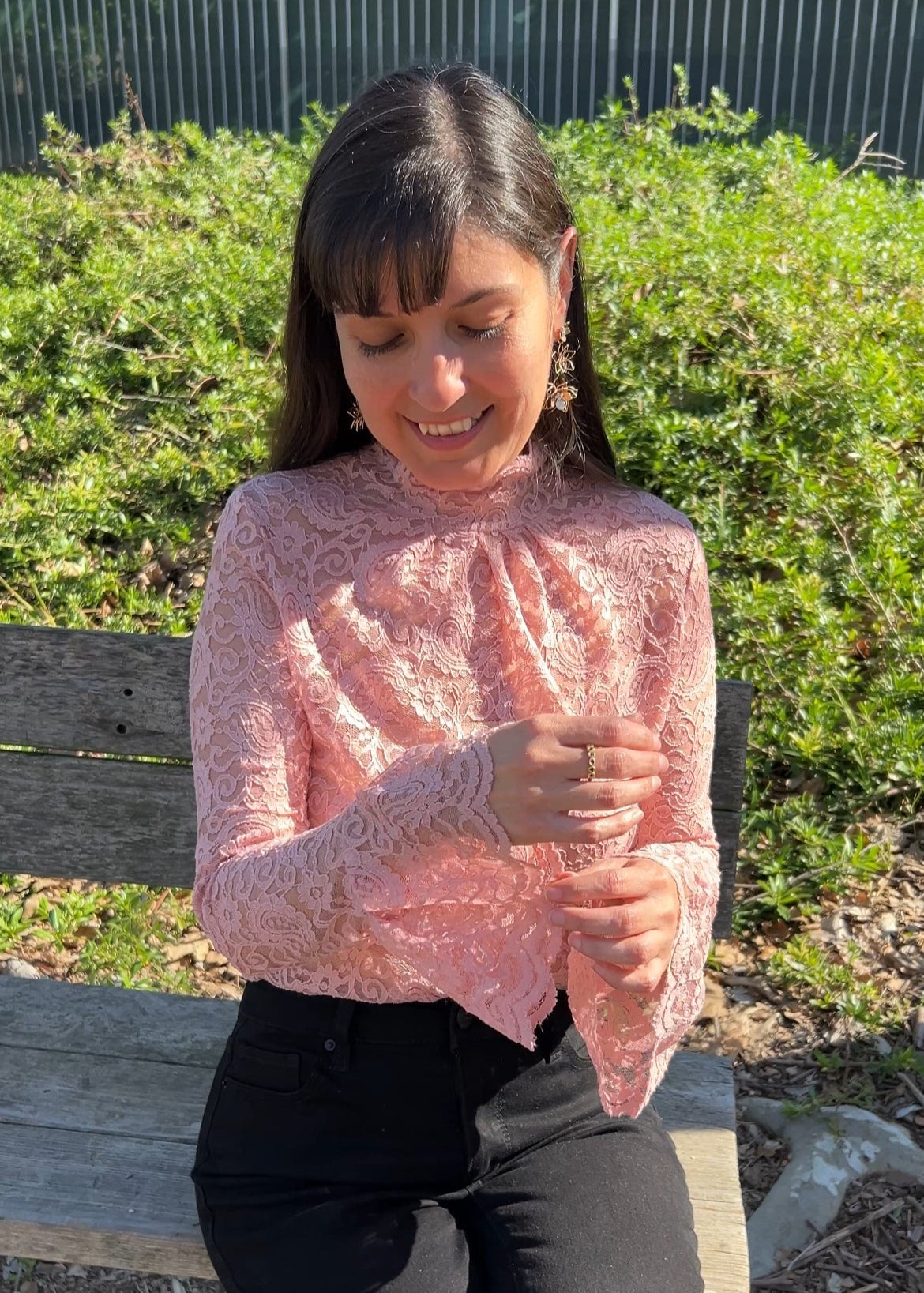 Woman in Pink Floral Lace Mock Neck Top with Flare Sleeves facing forward up close