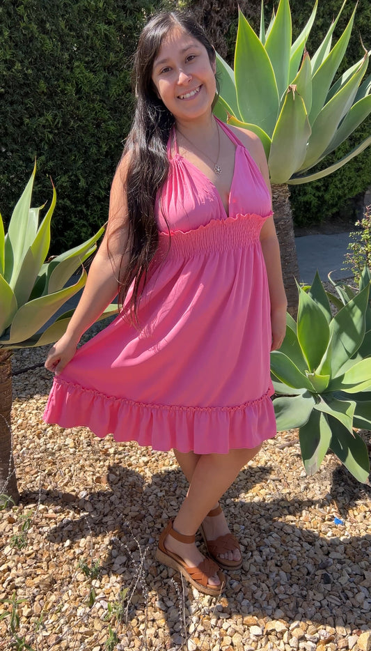 Woman in Pink Ruffle Trim Spaghetti Strap Mini Dress Smocked Waist Tie Back facing forward