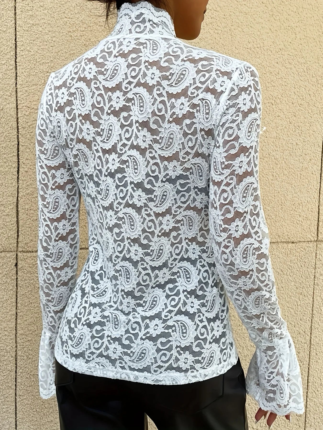 Woman in White Floral Lace Mock Neck Top with Flare Sleeves facing backwards up close